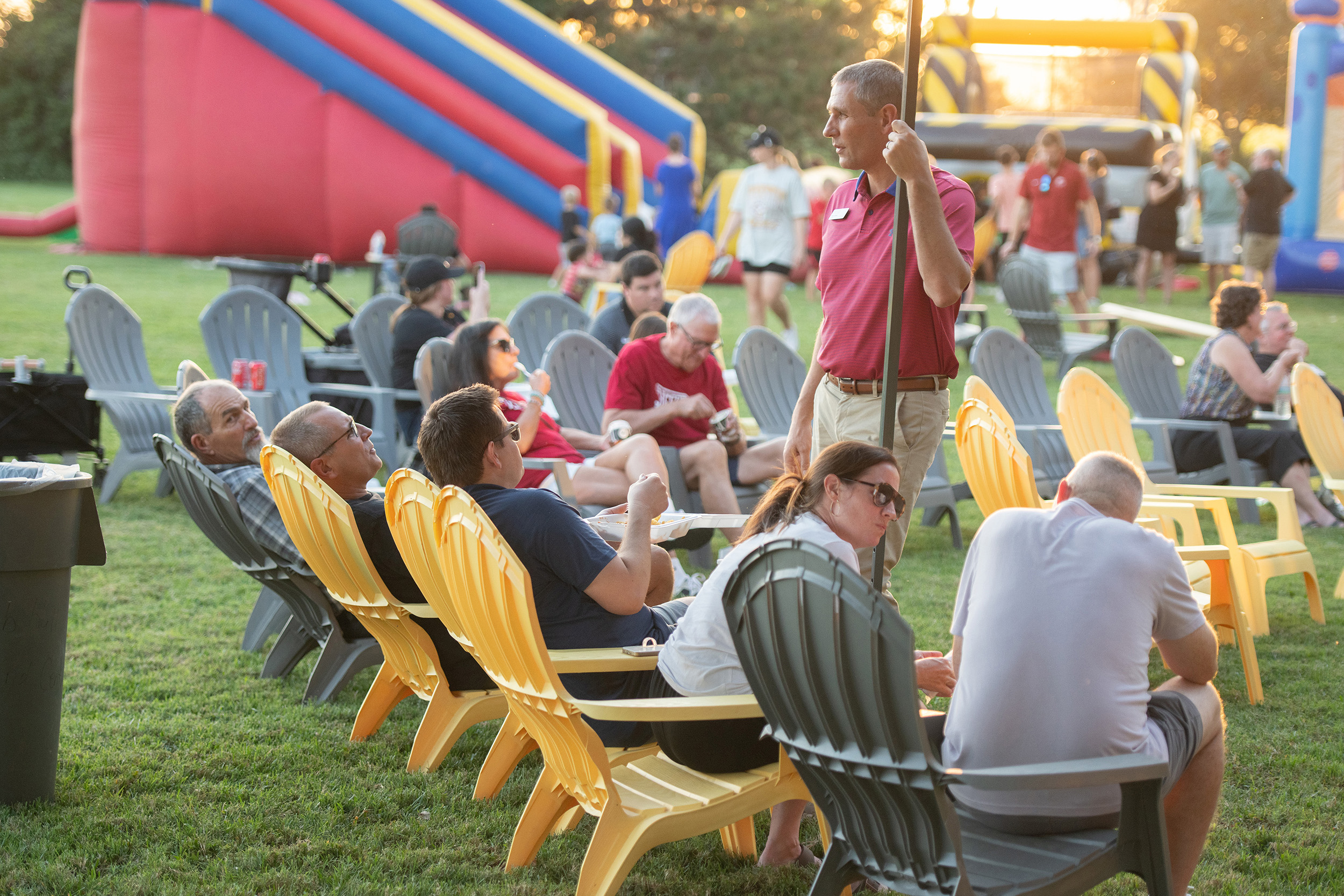 Group of adults sitting in lounge chairs chatting.
