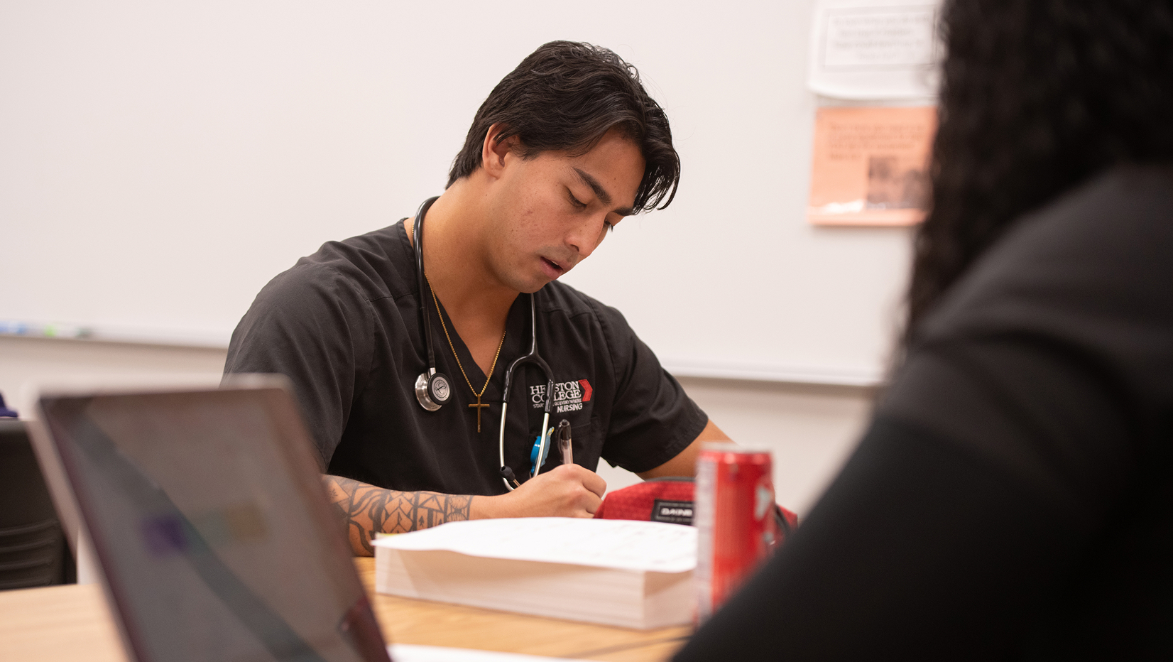 Male nursing student taking notes