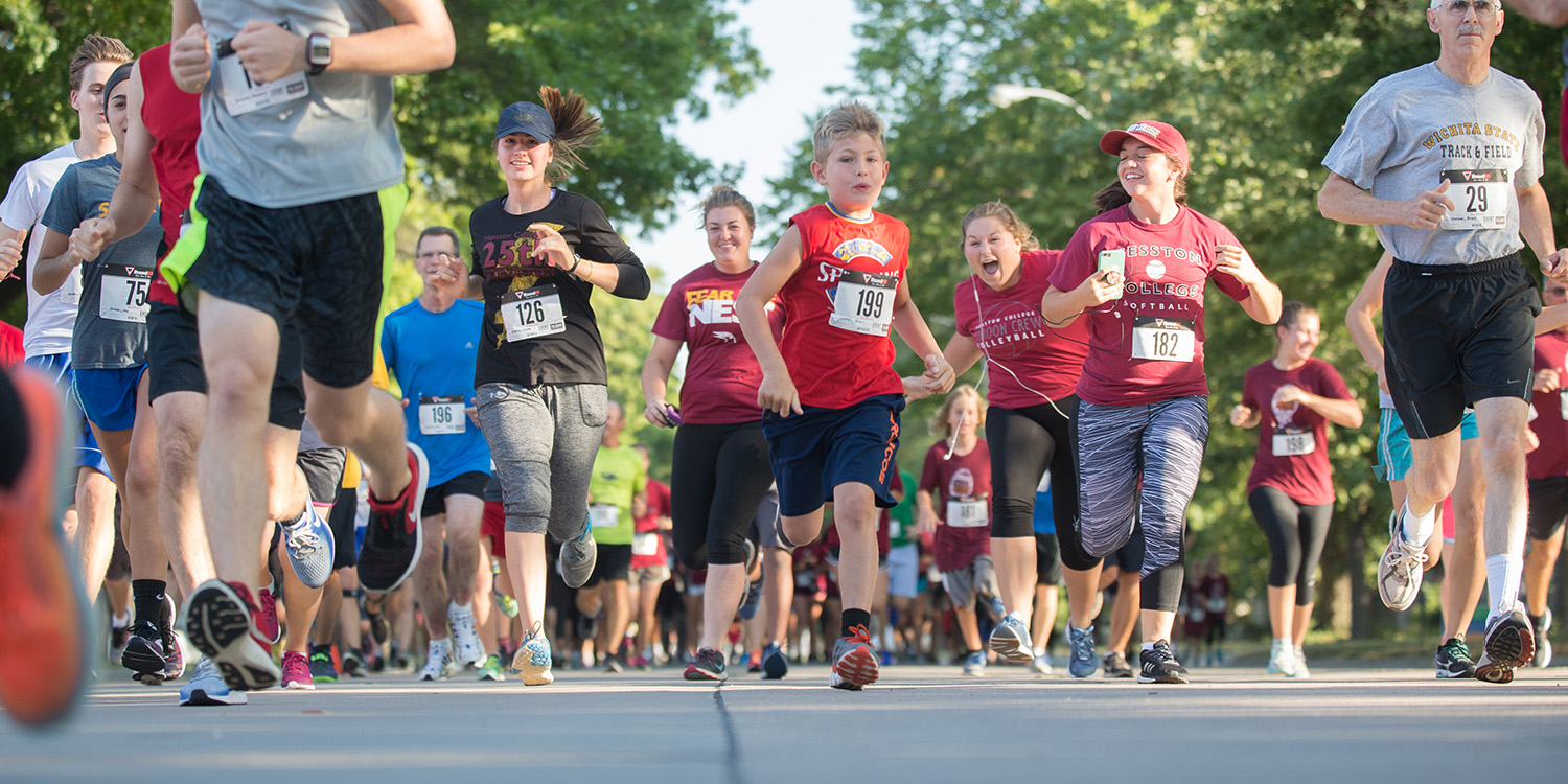 a crowd of runners running toward the camera at the start of the 2017 Manickam Mosey at Hesston College