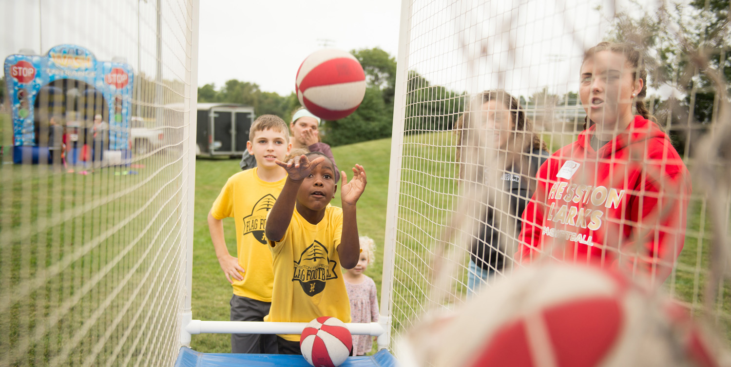 A child shoots baskets at a pop-a-shot game at Homecoming 2018