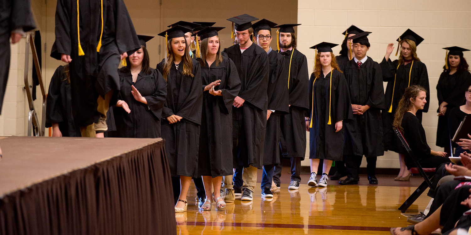 Graduates wait to receive their diplomas at commencement in May 2017