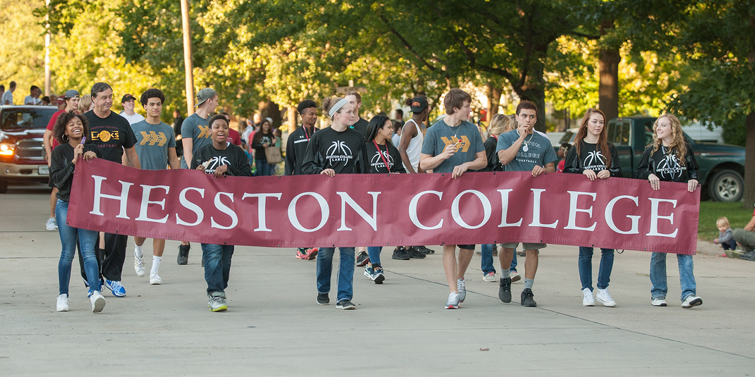 Photo - Lark women's basketball team carrying the Hesston College banner in the 2016 Home Sweet Hesston parade