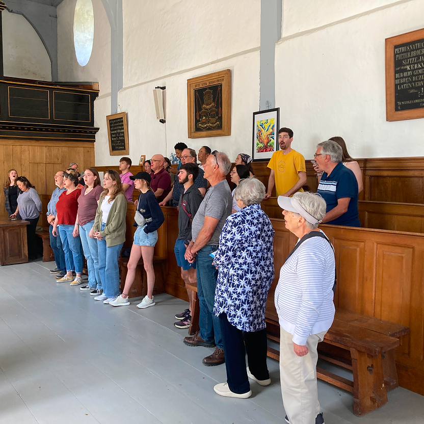 Group photo of singers of all ages together mid performance.