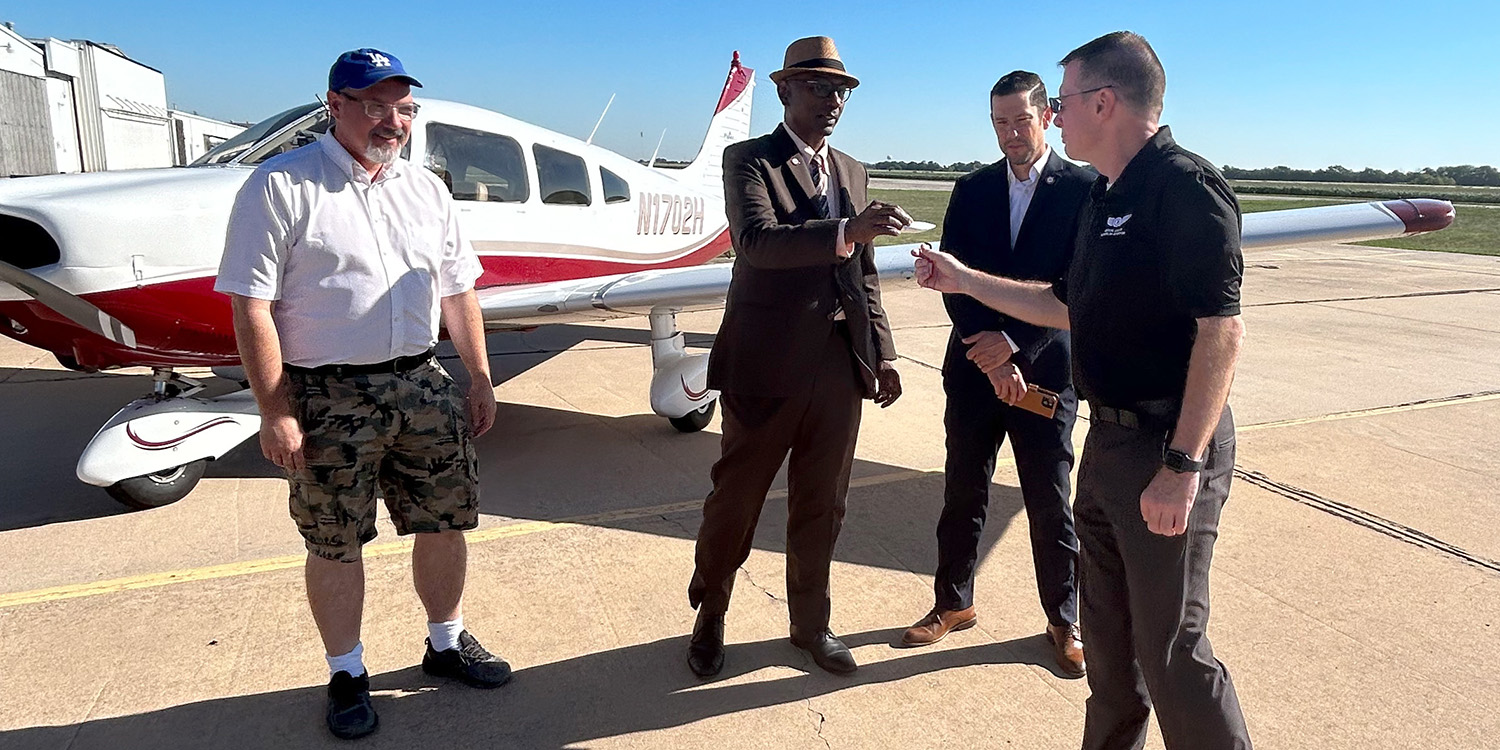 Man handing keys to new aircraft to another man.