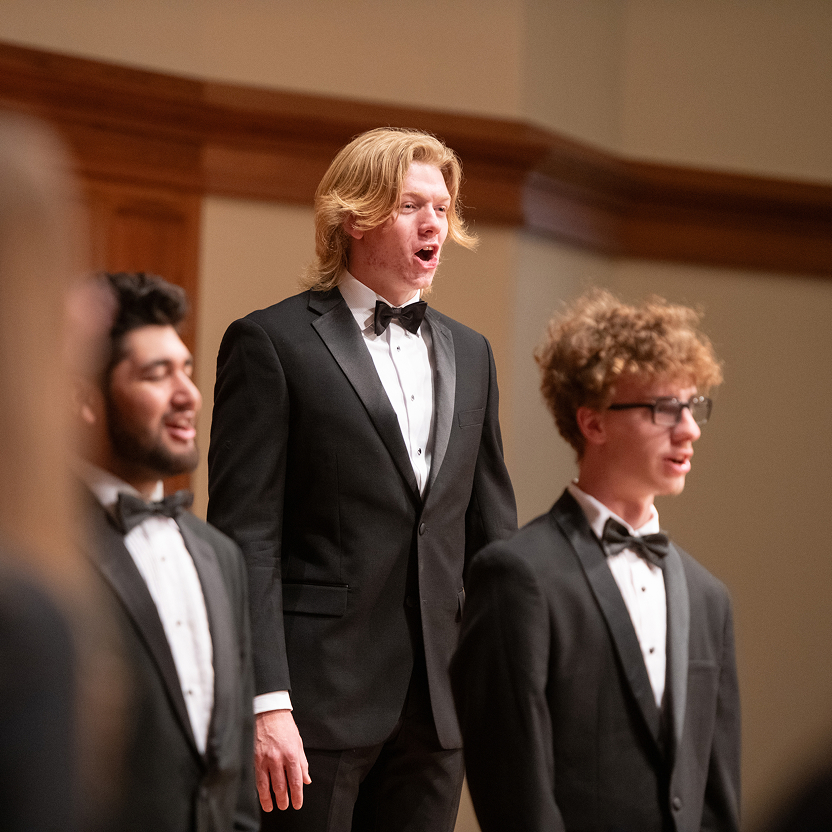 Close up of male student singers mid performance.